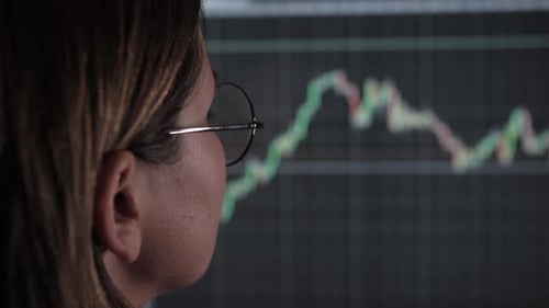 Woman Watching Financial Data on Screen