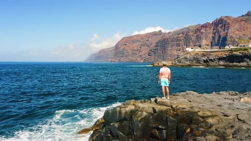 Man Tourist on Rocky Volcanic Beach