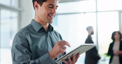 Smiling Man Using Tablet in Bright Office