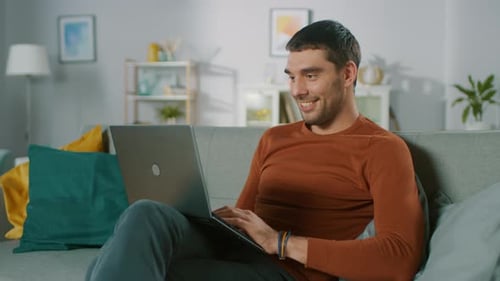 Man Relaxing on Couch Using Laptop at Home