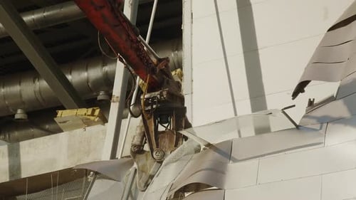 Une excavatrice avec manipulateur détruit un gros plan d'un stade de hockey