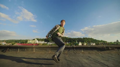 Kaukasischer gutaussehender Tänzer spielt Hip Hop draußen auf dem Dach Brünetter Mann genießt