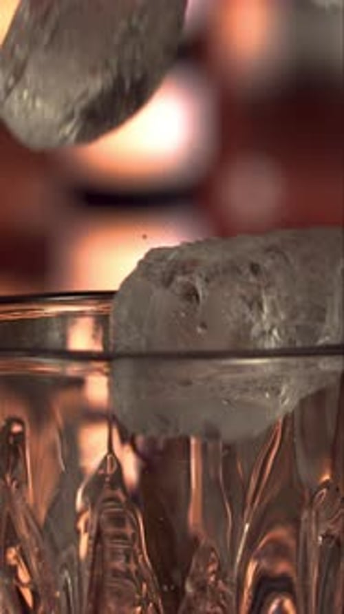 Ice Cubes Dropped in Glass in Slow Motion in Vertical