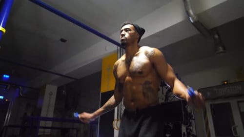 Strong African Athlete with Tattoos Skipping with a Jump Rope at Sport Club Young Black Sporty Man