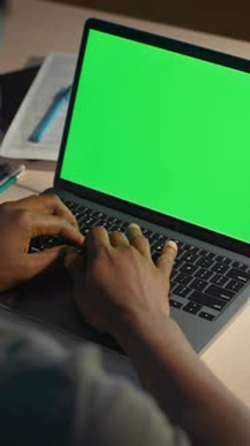 Hardworking Male Typing on Laptop with Blank Green Screen