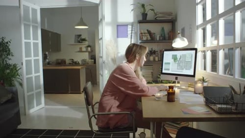 Woman Working on Computer at Desk in Home