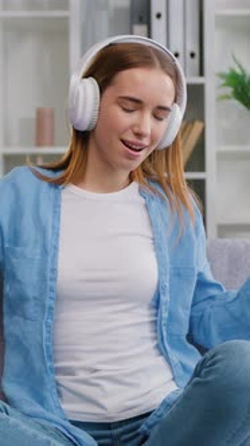 Woman with Headphones Singing and Dancing Indoors
