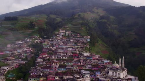 Aerial view of village, mountain, mosque, houses, and fields, Indonesia.