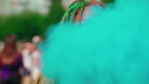 Woman Covered In Holi Color Blowing Powder