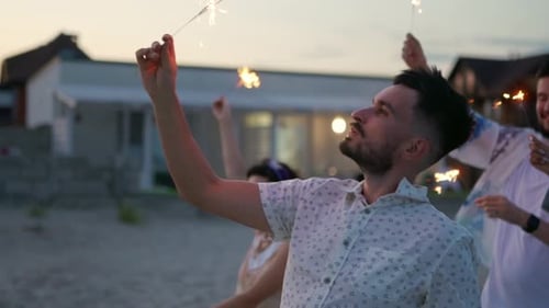 Friends Celebrate with Sparklers on Beach at Dusk