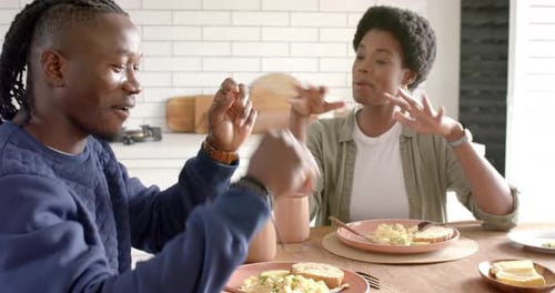 Cheerful Couple Enjoying Breakfast at Kitchen Table