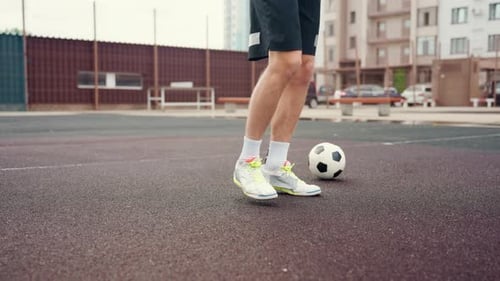 Man Juggling Soccer Ball with Feet on Outdoor Court
