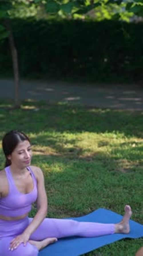 Practicing Yoga As a Group in the Park on a Summer Day