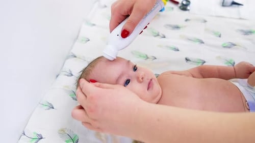 Baby Having Temperature Checked in Doctor's Office
