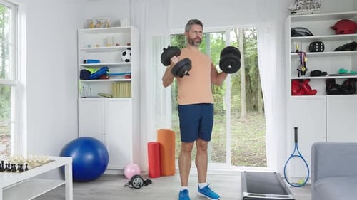 Man Working Out at Home Lifting Dumbbells