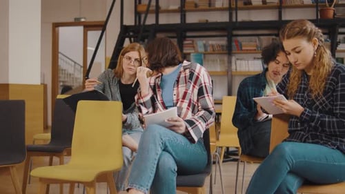 a Group of Students Study and Communicate While Sitting on Chairs in a Library or Classroom Students