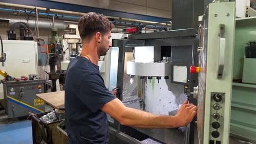 Man Operating Industrial Machine in Workshop