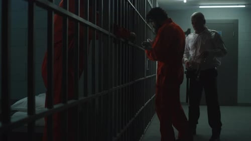 Jailer Leads Criminal in Orange Uniform to Prison Cell