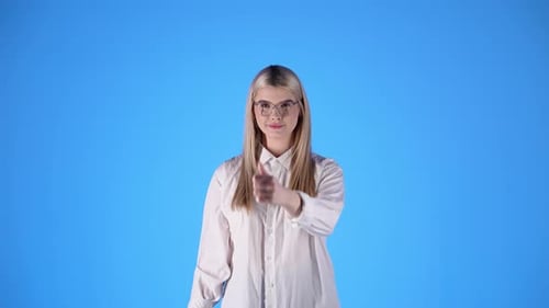 Woman with white shirt shows thumbs up, concept of approval, studio shot