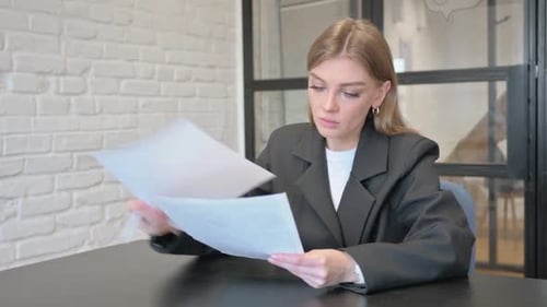 Businesswoman Reading Documents at Work in Office