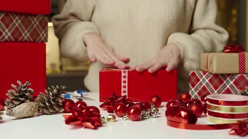 Wrapping Christmas Gifts with Red Ribbon and Ornaments