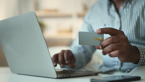Elderly African American Man Using a Credit Card at Home in His 60s