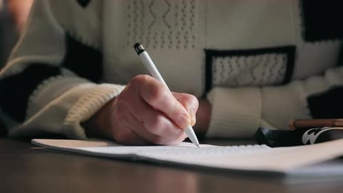 Close Up of Hand Writing in Notebook