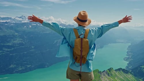 Woman Standing on a Mountain in the Alps View Raises His Hands in the Air Inhales Fresh Air Enjoys a