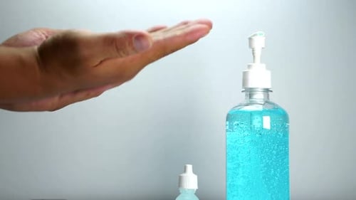 Asian man washing both hands with blue sanitize gel to keep hands clean and hygiene to prevent coron