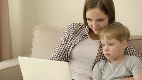 Mother and Son Using Laptop Together at Home