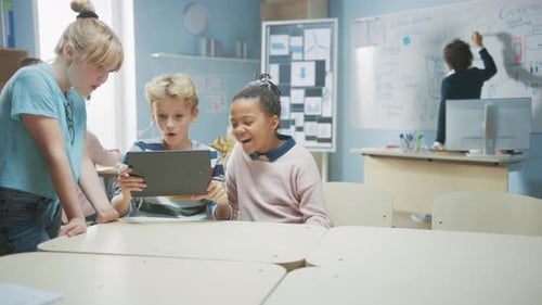 Elementary School Computer Science Class: Two Girls and Boy Use Digital Tablet Computer with Augmen