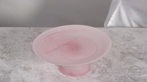 Zuckerguss von Funfettti Bundt Cake mit rosafarbenem Buttercreme-Frosting auf einem Kuchenständer