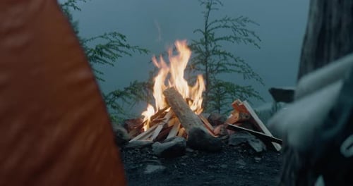 Campfire burning at a mountainside camp