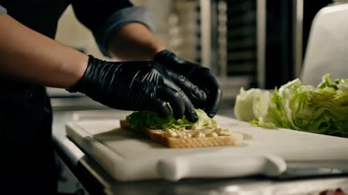 professional kitchen in a restaurant the chef lays out the ingredients for a club sandwich on toast