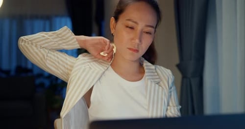 Woman Stretching at Computer Late at Night