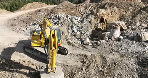 Industrial Mine Excavators are Digging the Soil in the Construction Site and Loading Trucks