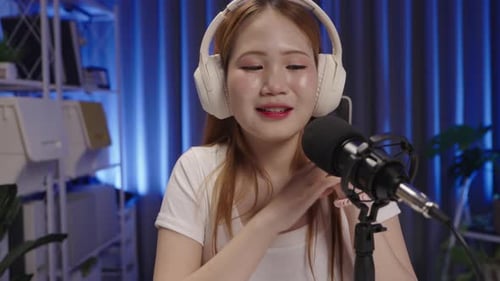 Podcast host responding to viewer comments during live stream, medium close up.