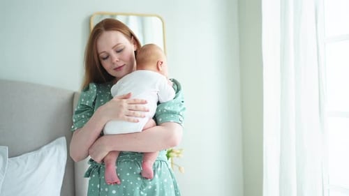 Loving Mother Holding Newborn Infant Indoors