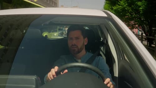 Man Talking in Car Driving Through City