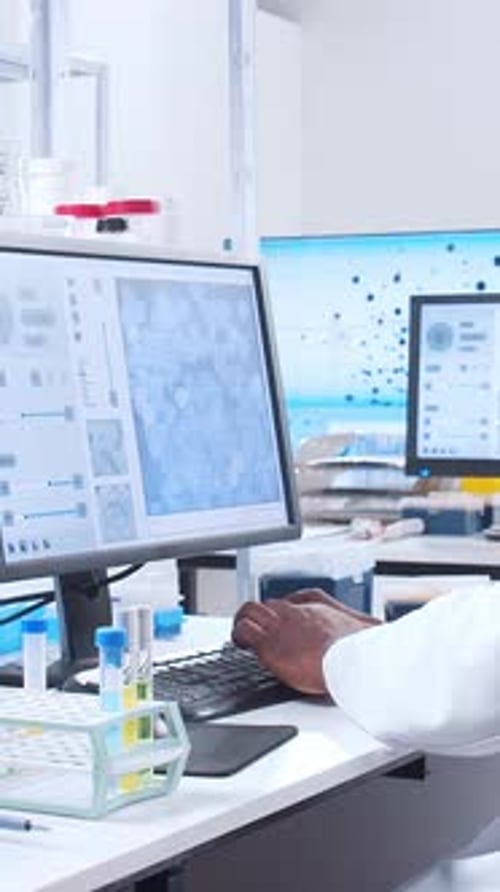 Scientist Typing at Computer in Medical Research Lab