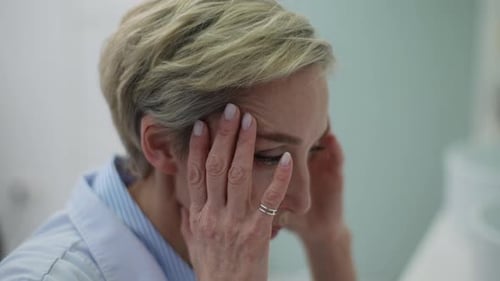 Blonde Woman Massages Temples for Headache Relief