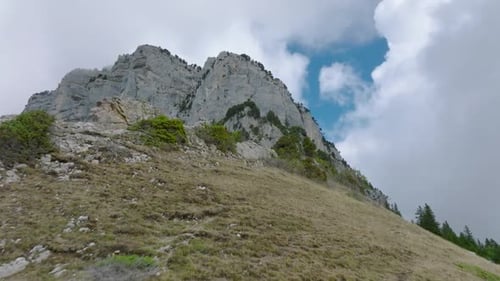 Subiendo una colina que supera un acantilado hasta una impresionante montaña rocosa, Alpes franceses