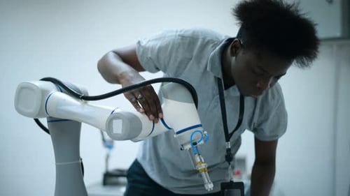 Focused Engineer Working on Robotic Arm