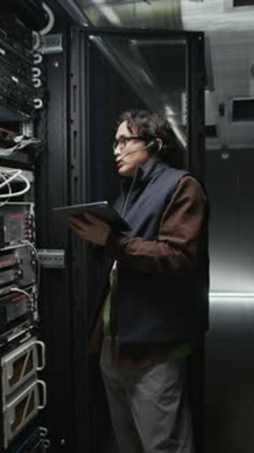 Vertical do engenheiro de data center gerenciando o rack de servidores com tablet digital