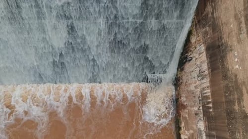 Flood waters cascading over a dam wall from a drone 9