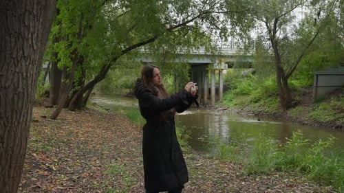 Woman Strolling Beside Tranquil River Calm Scene with Lady Near Flowing Water Tranquil Scene Showing