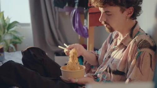 Young Adult Eating Noodles with Chopsticks