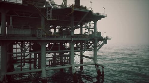 Oil Rig Stands Tall Over Calm Waters During a Hazy Day