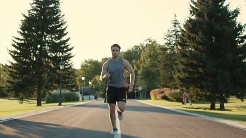 Male Runner Training to Run Marathon in Park at Sunset. Sport Man