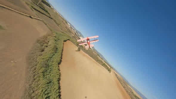 FPV drone chasing model remote control stunt biplane across rural ...